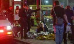 Secours et forces de sécurité israéliens se pressent autour d'un corps sans vie sur le lieu d'une attaque au couteau à Jérusalem, le 30 août 2023