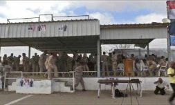 Une capture d'image d'une vidéo obtenue par l'AFPTV montrant des soldats yéménites et des reporters au moment de l'explosion d'un drone au dessus d'une parade militaire à al-Anad dans le sud du Yémen qui a fait au moins six morts, le 10 janvier 2019