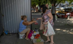 Une femme achète des tomates dans la ville ukrainienne de Marganets ( sud), le 12 août 2022 