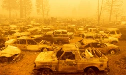 Des dizaines de véhicules brûlés sont plongés dans les épaisses fumées dégagées par le Dixie Fire à Greenville (Californie), le 6 août 2021