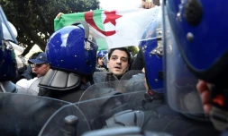 Un manifestant algérien fait face à la police antiémeute lors d'un rassemblement contre un 5e mandat du président Abdelaziz Bouteflika, à Alger le 24 février 2019