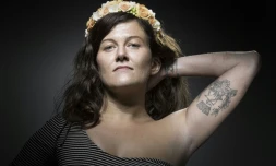 Alexandra D., qui prétendait avoir été blessée au bar du Carillon le 13 novembre 2015, montre son tatouage - la devise de Paris Fluctuat nec mergitur - lors d'une séance photo à Paris, le 26 juillet 2017