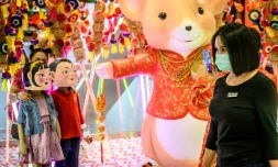 Une femme porte un masque de protection contre le nouveau coronavirus dans un magasin décoré pour le Nouvel An chinois à Bangkok le 24 janvier 2020