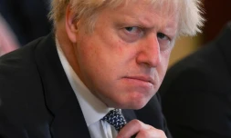 Le Premier ministre britannique, Boris Johnson, ajustant son noeud de cravate le 24 mai 2022 lors d'une réunion à Downing Street