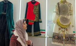 Une Iranienne regarde les crĂ©ations prĂ©sentĂ©es lors de l'exposition ayant lieu dans le cadre du festival national de la mode Ă TĂ©hĂ©ran, et les vĂȘtements conçus par de jeunes designers iraniens, le 21 janvier 2024