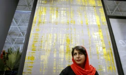 Une visiteuse devant un tapis fabriqué à Ispahan, lors d'une exposition de tapis, le 26 août 2022 à Téhéran