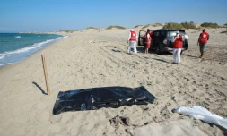 Des membres du Croissant Rouge cherchent le 26 juillet 2019 sur une plage de Khoms (Libye) les corps de migrants Ă bord d'une embarcation ayant fait naufrage
