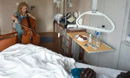 La violoncelliste musicothérapeuthe Claire Oppert au chevet d'un patient, le 11 juillet 2016 à Paris
