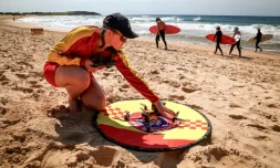 La secouriste Eliza Heys vérifie un drone aprÚs son atterrissage sur une plage à Sydney, le 1er octobre 2025