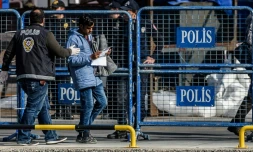 Un policier turc accompagne un migrant rapatrié depuis la Grèce à son arrivée au port d'Izmir, le 4 avril 2016