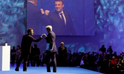 Le président Emmanuel Macron (g) salue l''envoyé américain pour le Climat John Kerry (d), à l'ouverture du sommet pour l'Océan, le 11 février 2022 à Brest