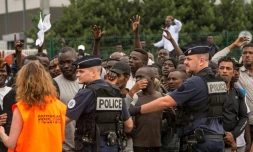 Une chargée de mission de la Préfecture du Nord-Pas-de-Calais sélectionne les migrants qui pourront monter à bord d'un bus à destination d'un Centre d'accueil et d'orientation, le 13 septembre 2016 à Calais