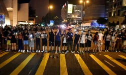 Des manifestants forment une chaßne humaine à Hong Kong dans une rue face au Centre culturel de la ville, le 23 août 2019