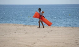 Un vacancier porte un masque de protection sur la plage de Lloret de Mar, le 22 juin 2020 en Espagne