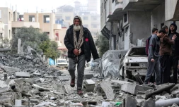 Un Palestinien marche au milieu des décombres d'une maison détruite par une frappe aérienne israélienne à Deir al-Balah, dans la bande de Gaza, le 13 mars 2024