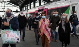 Des usagers portant des masques de protection arrivent à la gare Saint-Lazare, le 11 mai 2020 à Paris, au premier jour du déconfinement en France