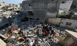 Des Palestiniens recherchent des survivants dans les décombres d'un bâtiment touché par une frappe israélienne à Bureij, dans le centre de la bande de Gaza, le 2 mai 2025
