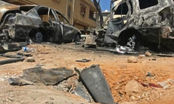 Les restes d'une roquette et des véhicules carbonisés le 17 avril 2019 dans un quartrier de Tripoli visé par des tirs la veille.