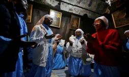 Des pèlerins chéritiens prient dans la grotte de la basilique de la Nativité, à Bethléem, en Cisjordanie occupée, le 24 décembre 2019