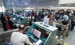 Des voyageurs masqués font la queue aux comptoirs d'enregistrement, le 27 juin 2020 à l'aéroport de Tunis