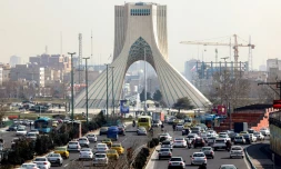 Des véhicules circulent sur une autoroute prÚs de la célÚbre Tour Azadi à Téhéran le 23 février 2026