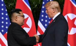 Le leader nord-coréen Kim Jong Un (g) et le président américain Donald Trump se serrent la main, avant le début du sommet, à l'hôtel Capella, le 12 juin 2018 à Singapour