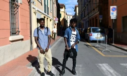 Blessed et Godwin, migrants du Nigeria, posent le 14 juin 2018 dans une rue de Vintimille, dans le nord de l'Italie, à proximité de la frontière avec la France
