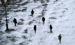 Des piétons marchent sur la neige, place de la Bourse à Paris le 1er mars 2018