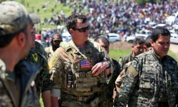 Un officier américain, de la coalition dirigée par les États-Unis, parle avec des combattants des unités de protection du peuple kurde (YPG) au nord-est de la ville kurde syrienne de Derik, connue sous le nom d'al-Malikiyah, le 25 avril, 2017