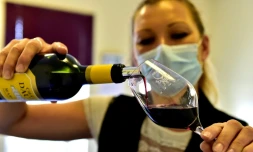 Une hĂŽtesse verse du vin qui va ĂȘtre goutĂ© par des professionnels Ă la maison du vin Ă Margaux, le 4 juin 2020