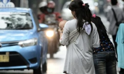 Une femme portant un enfant destiné à faire du co-voiturage à Jakarta, le 31 mars 2016