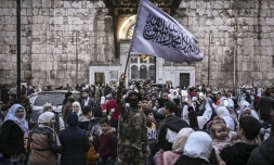 Un combattant rebelle brandit un drapeau islamique au souk Hamidiyeh, dans le Vieux Damas, le 11 décembre 2024