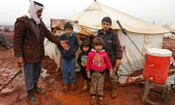 Abou Khaled pose avec ses enfants dans un camp de fortune de déplacés à Batabou, à la frontiÚre entre les provinces syriennes d'Idleb et d'Alep, le 24 janvier 2018