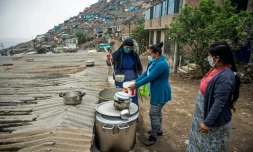 Une religieuse sert de la nourriture dans une soupe populaire d'un quartier pauvre de Lima (PĂ©rou) le 28 mai 2020, oĂč les habitants souffrent de la crise Ă©conomique entraĂźnĂ©e par la pandĂ©mie de nouveau coronavirus