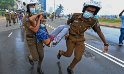 Des policiers emmènent un blessé devant la présidence srilankaise, à Colombo le 9 mai 2022
