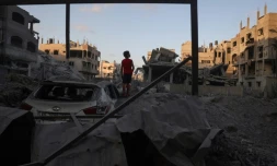 Un jeune Palestinien se tient près de gravats d'un bâtiment détruit par un bombardement israélien dans le camp de réfugiés de Nousseirat, dans le centre de la bande de Gaza, le 22 août 2024, sur fond de guerre entre Israël et le mouvement islamiste Hamas