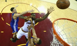 L'ailier des Cleveland Cavaliers Lebron James (c) shoote entre les deux stars de Golden State Stephen Curry (d) et Klay Thompson (g) lors de la victoire de son équipe contre les Wariors dans le 3e match des Finales NBA