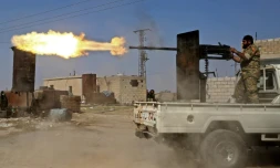 Un combattant syrien proturc tire à la mitrailleuse lors de combats dans la ville de Ras al-Aïn dans le nord de la Syrie, le 13 octobre 2019 