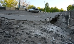 une voiture passe sur un pont endommagé près du village de Pechenegi, dans la région de Kharkiv, le 5 mai 2022
