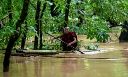 Un moine bouddhiste utilise un radeau de bambou au milieu des inondations à Taungoo, dans la région de Bago, en Birmanie, le 14 septembre 2024