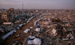 Des Palestiniens marchent près de tentes installées en pleine rue au milieu des ruines de bâtiments détruits, le 18 février 2025 à Jabalia dans la bande de Gaza