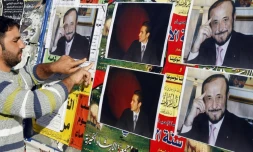 Un homme colle des affiches de Rifaat al-Assad, l'oncle du président syrien, le 6 décembre 2007 à Tripoli