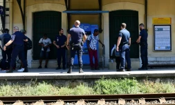 Des policiers contrôlent des migrants qui ont traversé la frontière avec l'Italie, le 14 juin 2018 à la gare de Menton