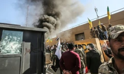 Des membres et partisans du Hachd al-Chaabi, coalition de paramilitaires dominée par des factions pro-Iran, incendient une tourelle devant l'ambassade des Etats-Unis à Bagdad le 31 décembre 2019