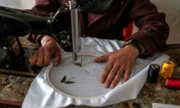 La couturière Rahima Alavi brode à la machine à coudre un tissu dans sa boutique à Bamiyan, le 26 janvier 2026 en Afghanistan