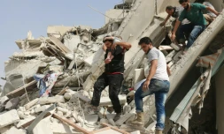 Un habitant évacue un enfant des décombres d'un immeuble aprÚs des raids aériens, le 21 septembre 2016 à Alep, en Syrie