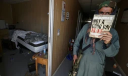 Un combattant taliban montre un exemplaire du livre "Not a Good Day to Die", dans une baraque militaire de l'aéroport de Kaboul abandonnée par les Américains, le 14 septembre 2021