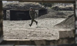 Un soldat arménien court pour se mettre à l'abri sur la ligne de front de la région séparatiste Nagorny Karabkah durant des combats contre l'armée azerbaïdjanaise le 18 octobre 2020