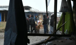 Des migrants de la "Jungle" de Calais autour d'un brasero pour se réchauffer, le 23 octobre 2016, à la veille du démantèlement du campement