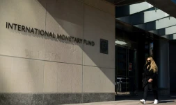 SiĂšge du FMI Ă Washington, oĂč une femme portant un masque contre le coronvirus marche le 5 avril 2021.